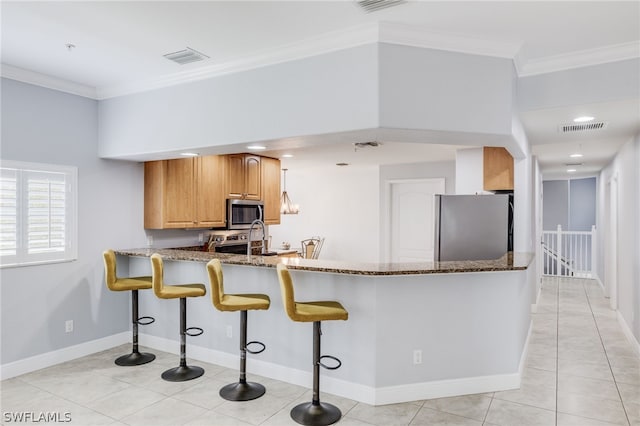 kitchen featuring light stone countertops, appliances with stainless steel finishes, ornamental molding, kitchen peninsula, and light tile patterned floors