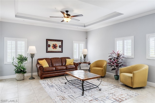 tiled living room featuring a raised ceiling, plenty of natural light, and ornamental molding