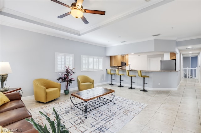 living room featuring ceiling fan, sink, crown molding, and light tile patterned flooring