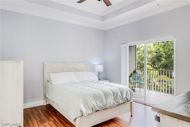 bedroom with ceiling fan, access to outside, a raised ceiling, crown molding, and dark hardwood / wood-style flooring