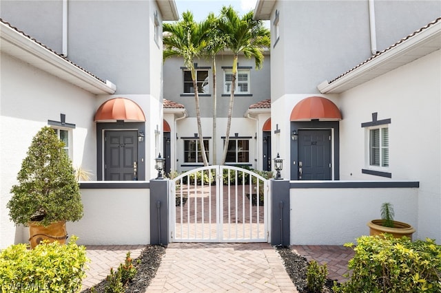 12101 Santaluz Dr Unit 102, Fort Myers, FL 33913 - view of exterior entry with fence and stucco siding