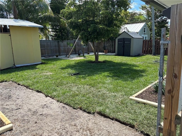 view of yard featuring an outbuilding, a shed, and a fenced backyard