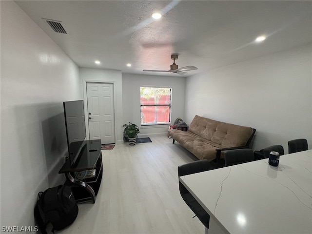 living room with light wood-type flooring and ceiling fan