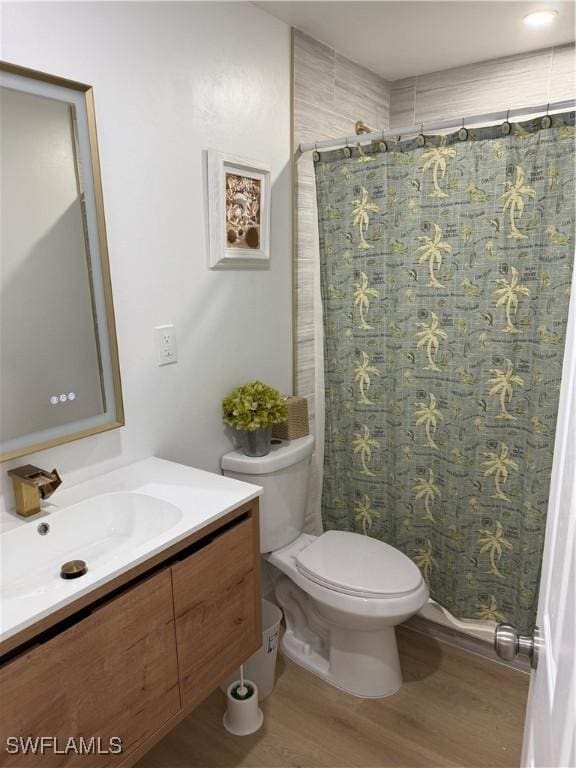 bathroom featuring a shower with shower curtain, vanity, toilet, and wood finished floors