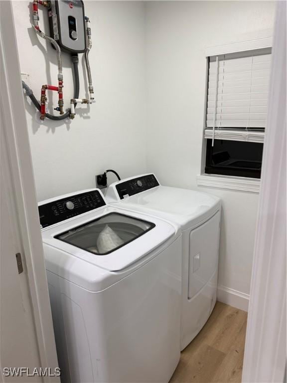 laundry area featuring laundry area, light wood-style flooring, baseboards, and separate washer and dryer