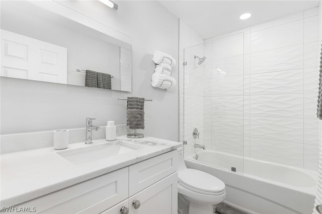 full bathroom featuring tiled shower / bath, vanity, and toilet