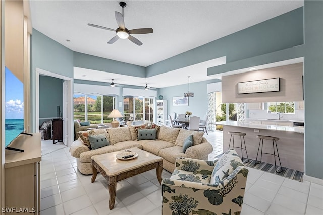 tiled living room featuring ceiling fan, a healthy amount of sunlight, and sink