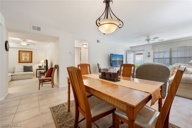 carpeted dining space with ceiling fan