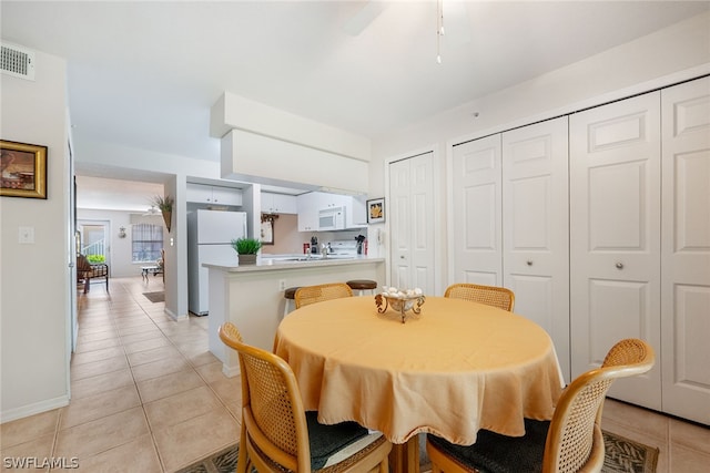 dining area featuring ceiling fan and light tile floors