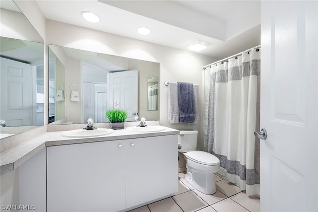 bathroom featuring tile flooring, dual sinks, vanity with extensive cabinet space, and toilet