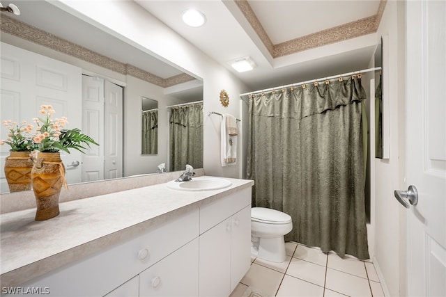 bathroom with large vanity, a tray ceiling, toilet, and tile flooring