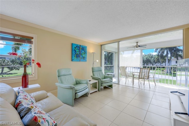 living room featuring crown molding, ceiling fan, a textured ceiling, and light tile flooring