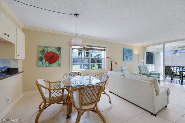 tiled dining area with a textured ceiling and crown molding