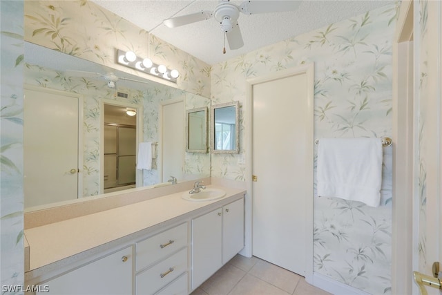 bathroom featuring tile flooring, ceiling fan, vanity, and a textured ceiling