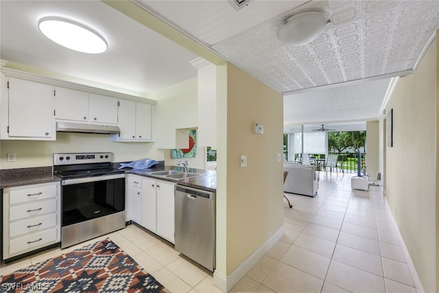 kitchen with white cabinetry, stainless steel appliances, sink, light tile floors, and floor to ceiling windows