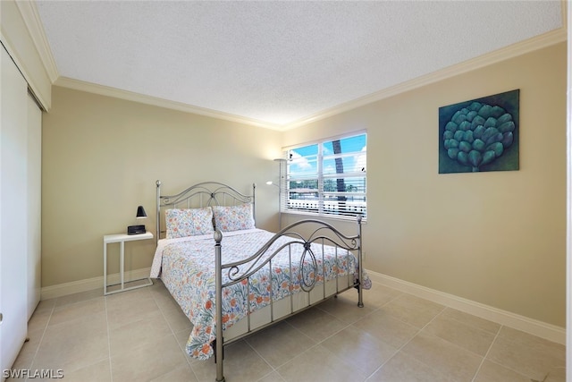 tiled bedroom featuring ornamental molding, a closet, and a textured ceiling