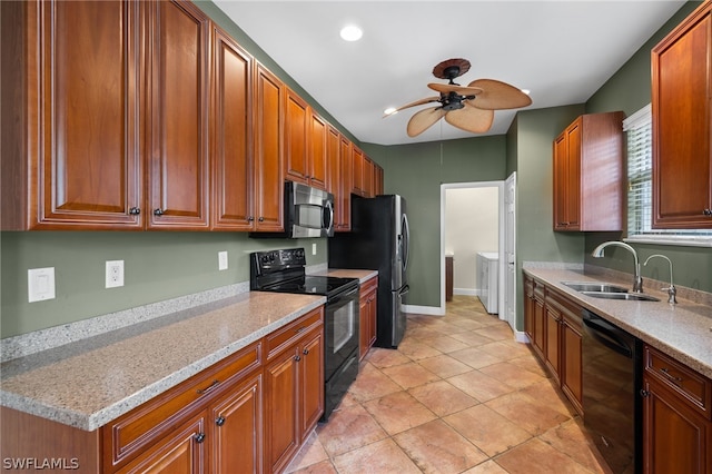 kitchen featuring sink, ceiling fan, independent washer and dryer, light stone countertops, and black appliances