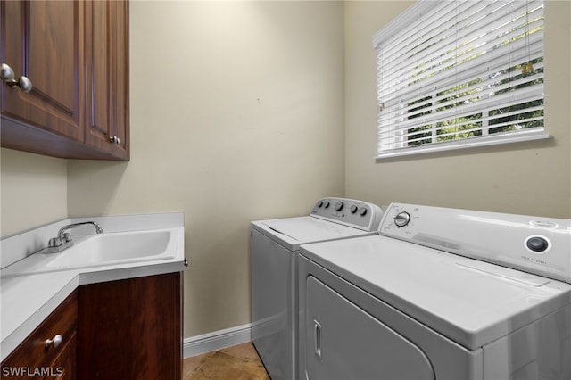 washroom with cabinets, sink, independent washer and dryer, and light tile floors