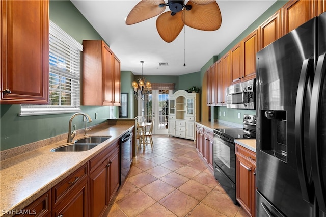 kitchen featuring sink, light stone counters, light tile patterned floors, pendant lighting, and black appliances