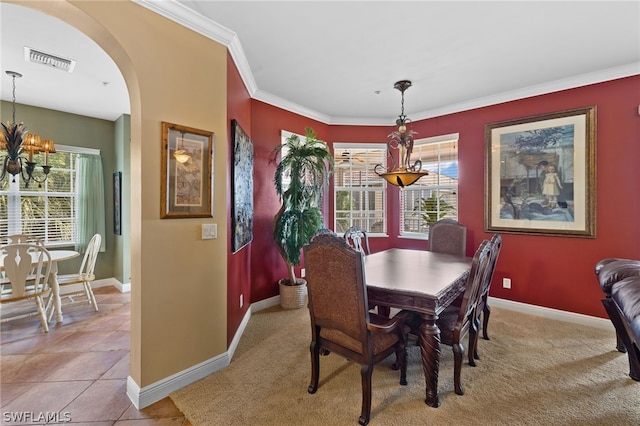 tiled dining area with crown molding and an inviting chandelier