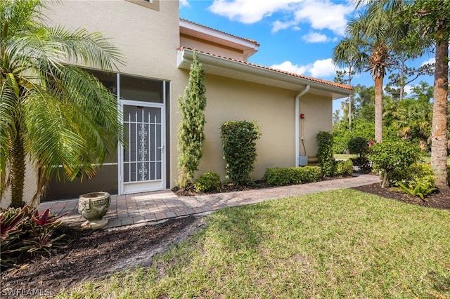 entrance to property featuring a lawn