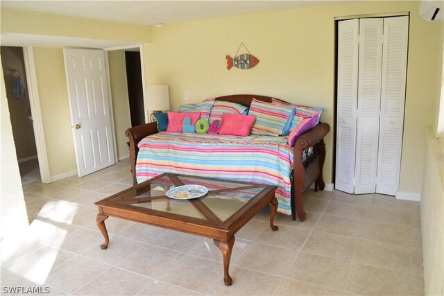 bedroom with a closet, a wall mounted AC, and tile floors