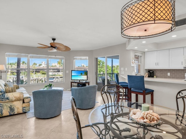 dining space with a wealth of natural light, ceiling fan, and light tile floors