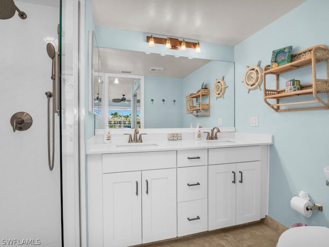 bathroom featuring dual sinks, large vanity, and tiled shower