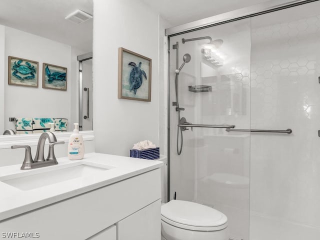 bathroom featuring a shower with door, toilet, and oversized vanity