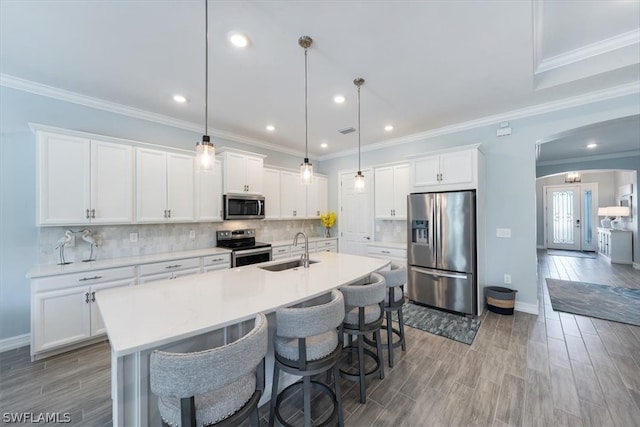 kitchen with pendant lighting, white cabinetry, sink, and stainless steel appliances