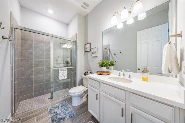 bathroom with vanity, toilet, and a shower with shower door