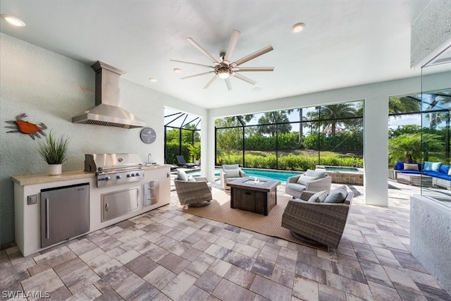 view of patio / terrace featuring an in ground hot tub, an outdoor living space with a fire pit, a lanai, exterior kitchen, and a grill