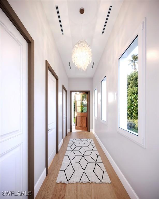 entryway featuring a wealth of natural light, light hardwood / wood-style floors, and a notable chandelier