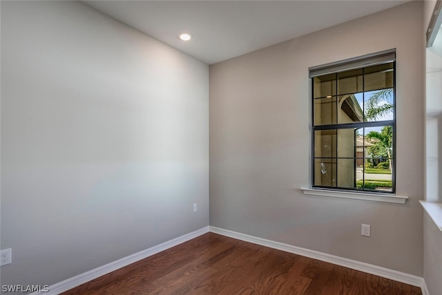 unfurnished room with dark hardwood / wood-style flooring