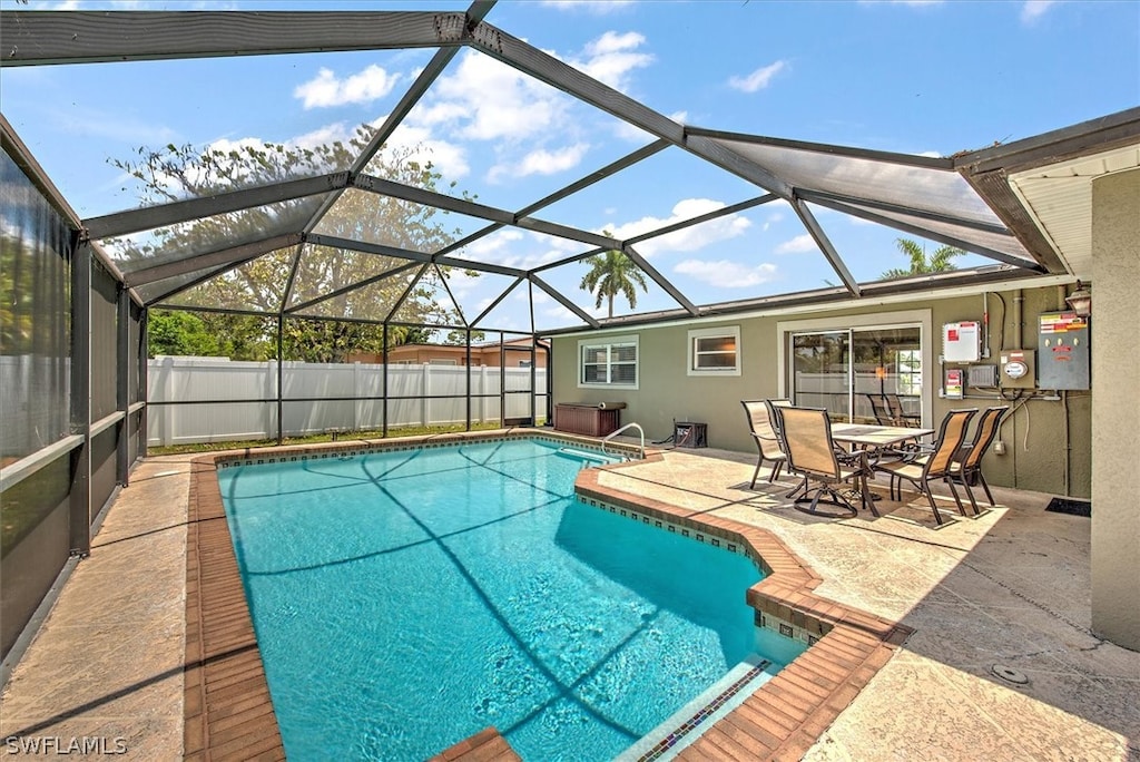 view of swimming pool with a patio area and a lanai