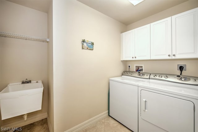 clothes washing area featuring washing machine and dryer, light tile flooring, hookup for an electric dryer, hookup for a washing machine, and cabinets