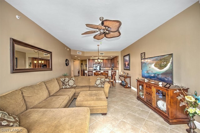 living room featuring ceiling fan with notable chandelier and light tile floors