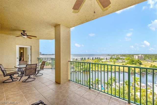 balcony featuring ceiling fan and a water view