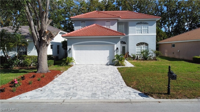 mediterranean / spanish-style house featuring a garage and a front lawn