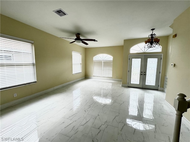 entryway with french doors and ceiling fan with notable chandelier