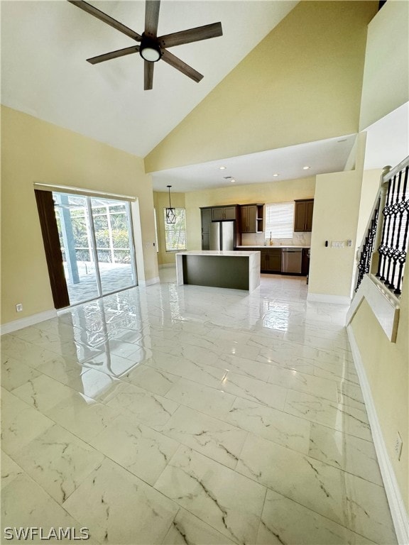 unfurnished living room with ceiling fan, sink, and high vaulted ceiling