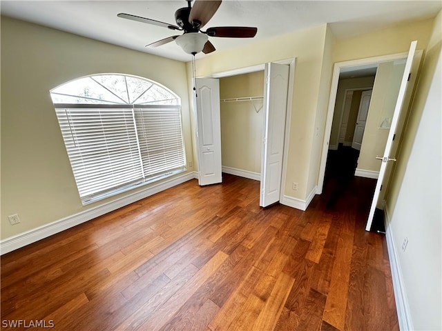 unfurnished bedroom with a closet, ceiling fan, and dark wood-type flooring