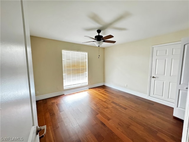 empty room with ceiling fan and dark wood-type flooring