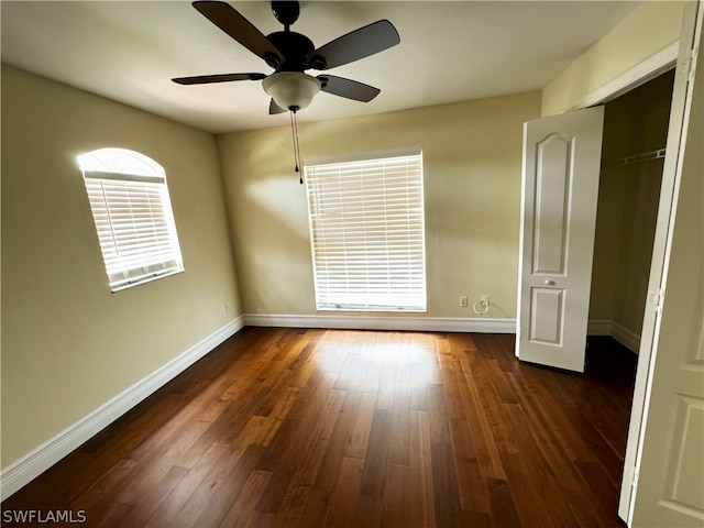 unfurnished bedroom featuring ceiling fan, a closet, and dark wood-type flooring