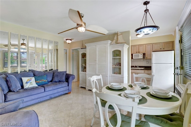 tiled dining room with ceiling fan with notable chandelier