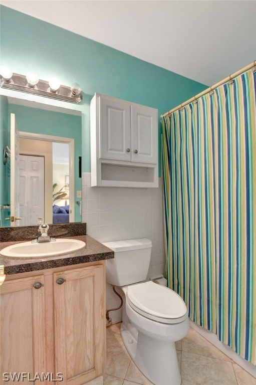 bathroom with tile walls, toilet, tile floors, and vanity