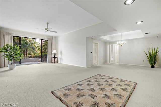 living room featuring ceiling fan with notable chandelier, carpet floors, and a tray ceiling