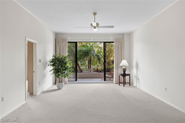 carpeted empty room with ceiling fan and crown molding