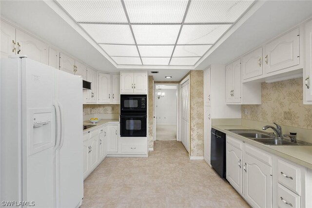 kitchen with white cabinets, sink, ventilation hood, and black appliances