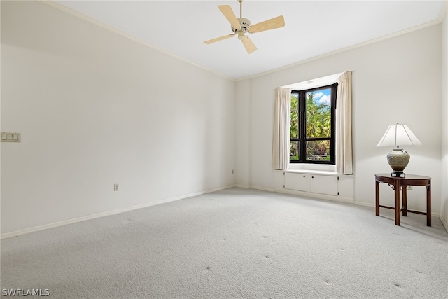 carpeted spare room with ceiling fan and ornamental molding